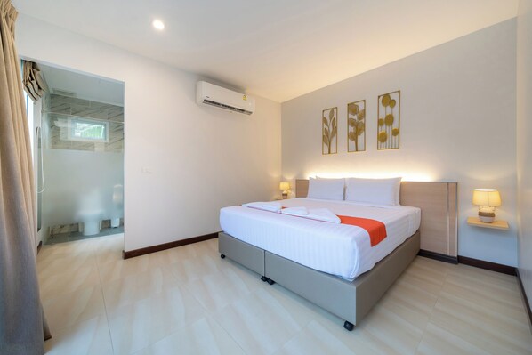 A modern hotel room with a bed, bedside lamps, an air conditioning unit, and artwork on the wall. - Phuket La Siesta Pool Villa And Pool Access (Rawai)