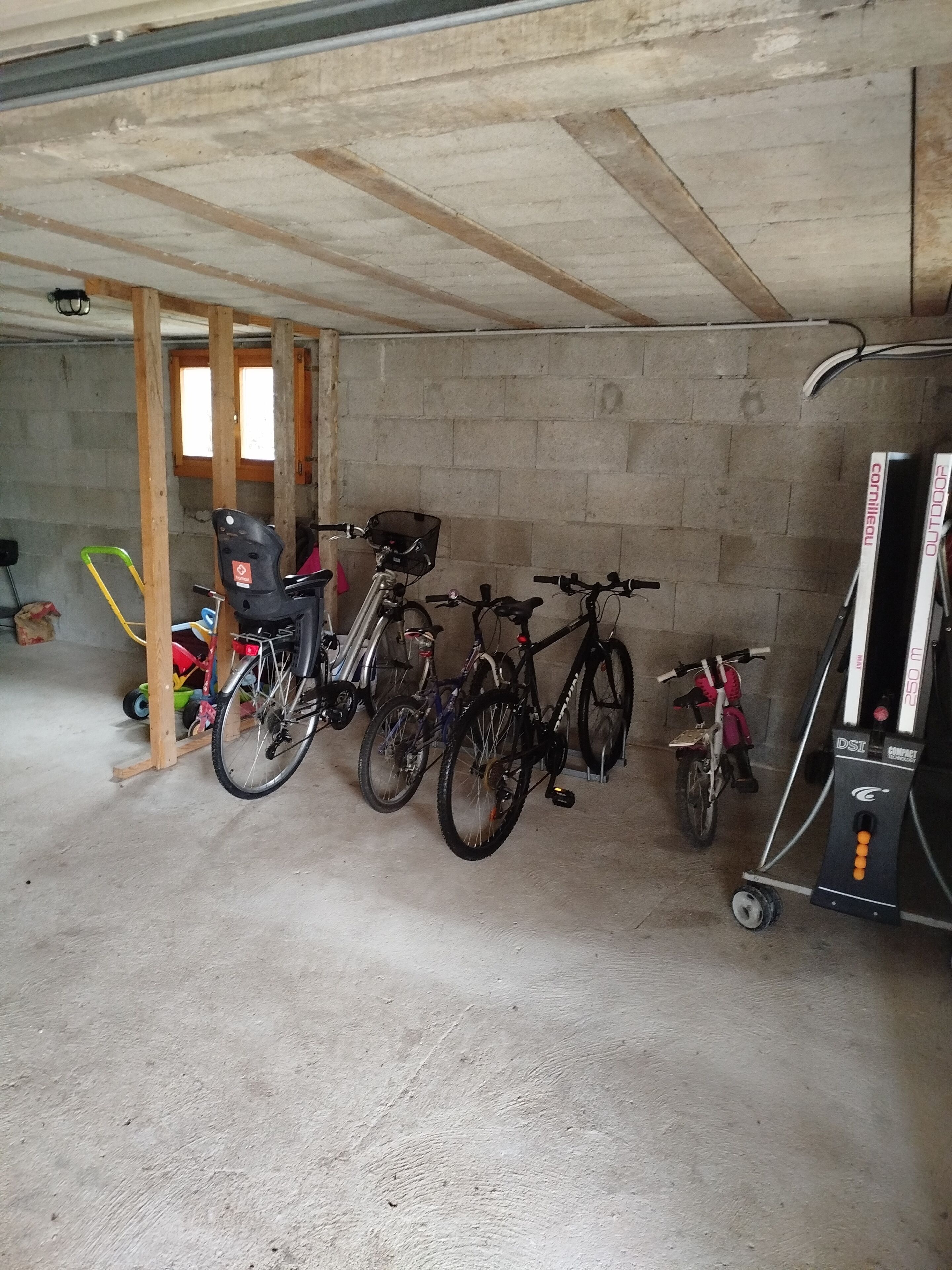 A garage with bicycles parked against the wall.