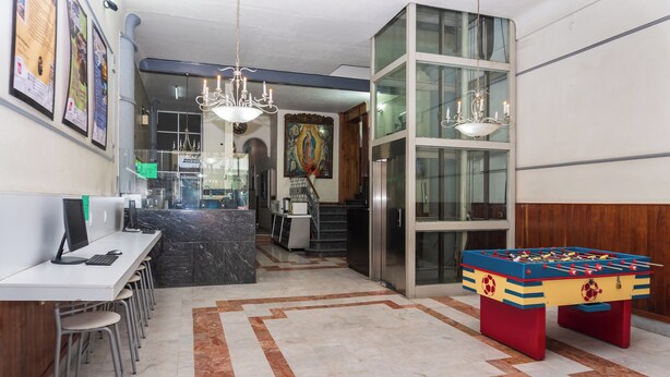 Eine moderne Lobby mit einem Tischkicker, einer Rezeption und einer Kristallleuchtre.'