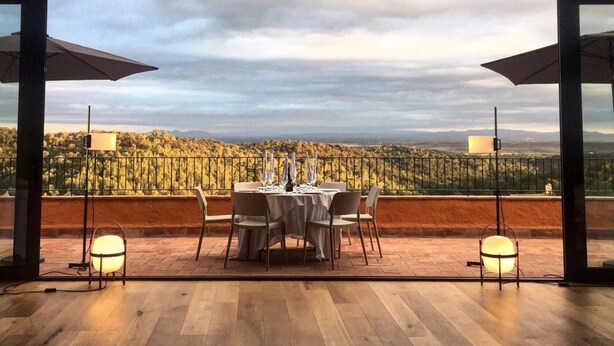 A dining area with a table set for four, overlooking a scenic landscape. - Country house in Vilamaniscle - Girona (Vilamaniscle)