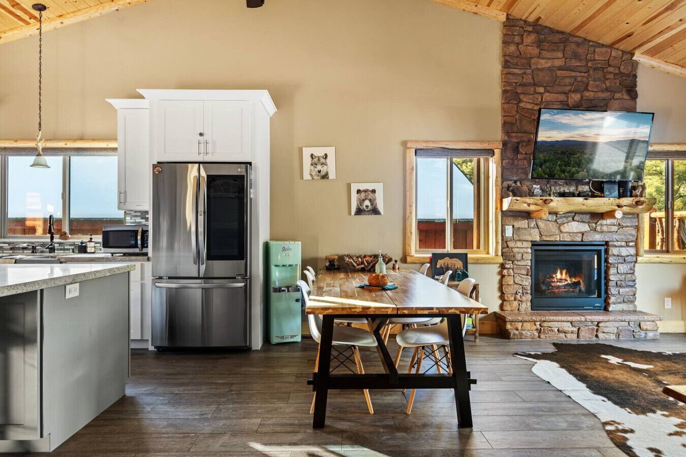 Une cuisine moderne équipée d’un réfrigérateur, d’une cuisinière et d’un coin repas avec une table et des chaises.