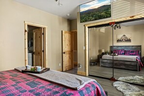 Une chambre à coucher avec un lit, une télévision et une grande fenêtre.