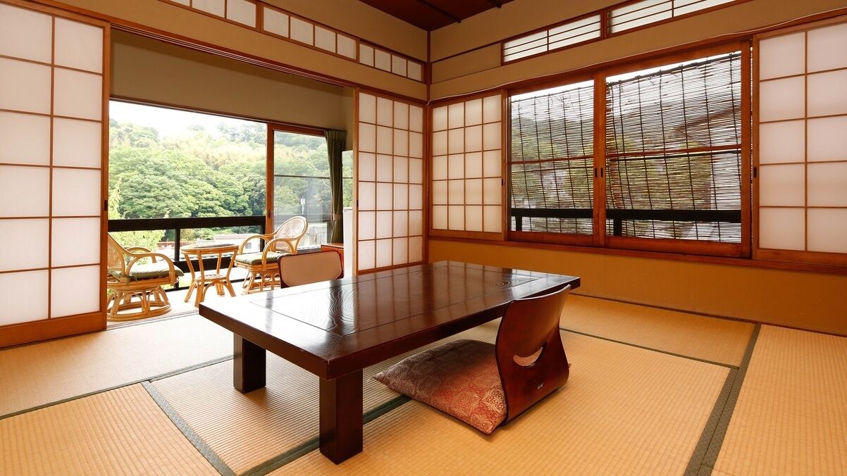 A traditional Japanese room with tatami flooring, a low table, and sliding shoji doors.