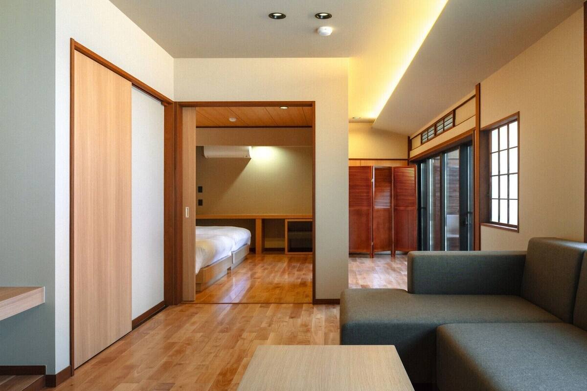 Una habitación de hotel compacta con sofá, una mesita, cama y armario.