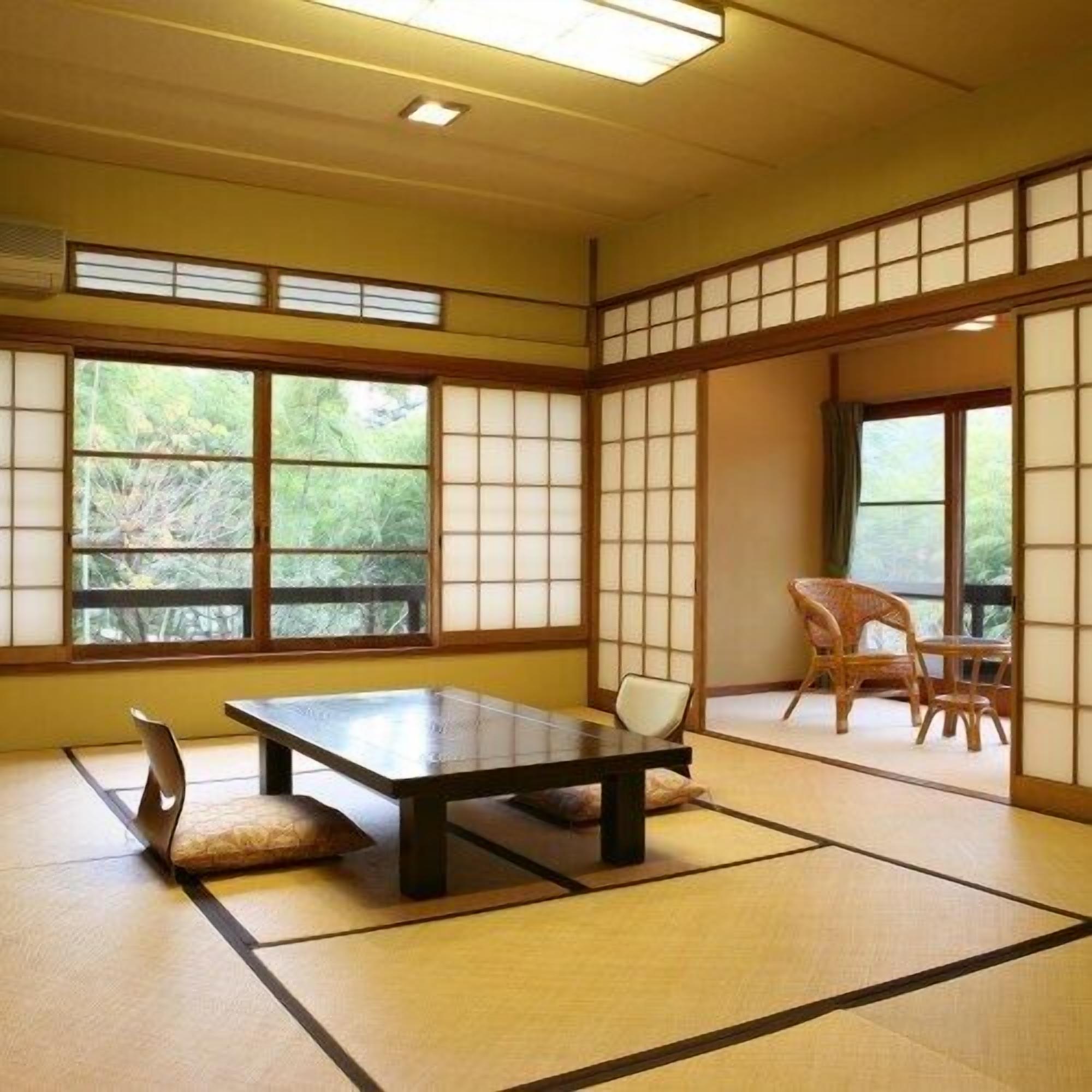 A traditional Japanese room with tatami flooring, a low table, and sliding doors.
