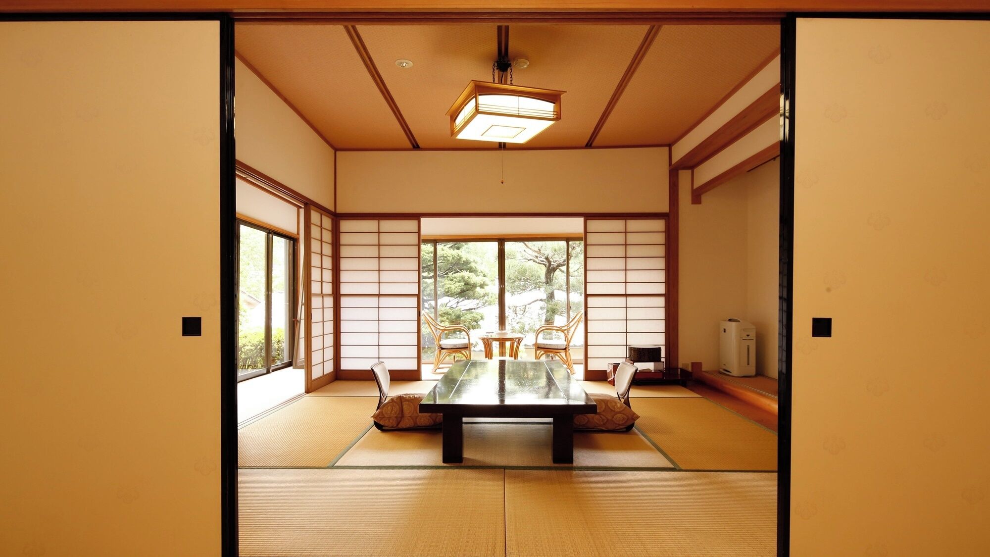 A traditional Japanese room with tatami flooring, a low table, and sliding doors.