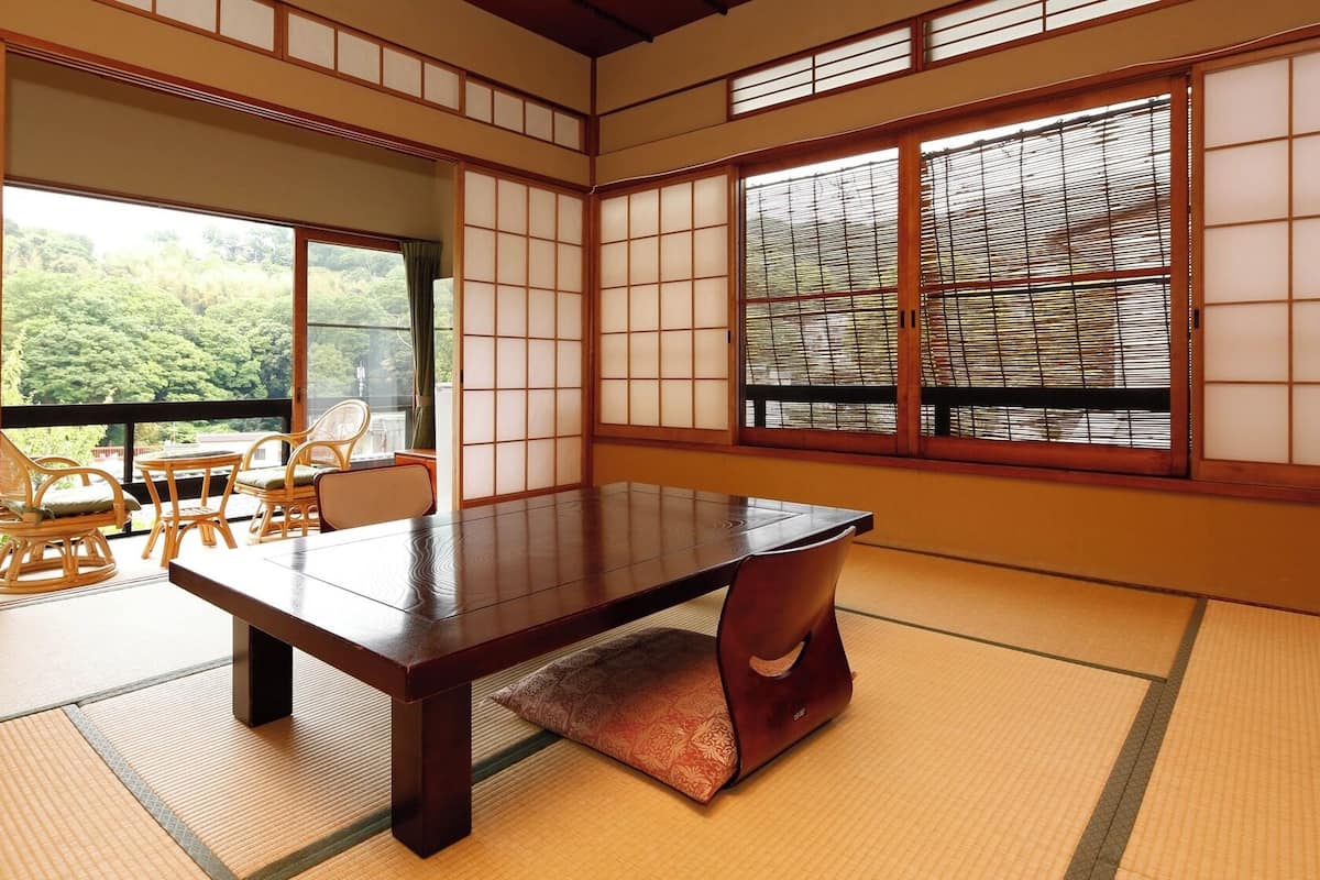 A traditional Japanese room with tatami flooring, a low table, and sliding doors.