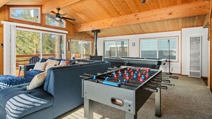 Ein gemütliches Zimmer mit einem Kicker, einer Couch und einem Deckenventilator.