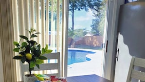 A dining table with a placemat, a bowl of snacks, and a potted plant with flowers.