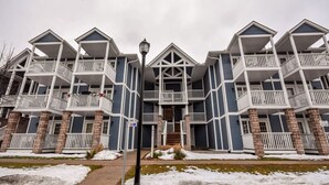 A multi-story building with a symmetrical facade, featuring balconies and a central entrance. - Classic Spacious Studio Suite! (Shanty Bay)