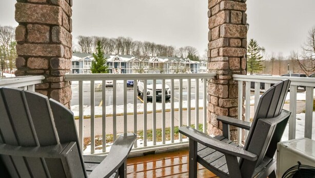A stone pillar and a white railing on a porch with two Adirondack chairs. - Classic Spacious Studio Suite! (Shanty Bay)