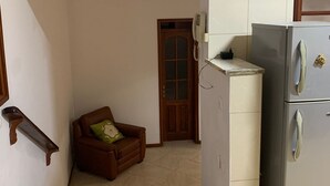 Una cocina compacta con refrigerador y un armario de madera.