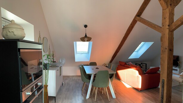 A modern loft apartment with a dining area, kitchen, and living space.