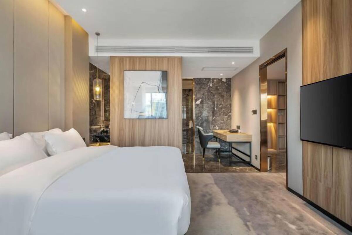Een moderne hotelkamer met een groot bed, een zithoek en een televisie.