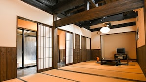 Ein traditioneller japanischer Raum mit Tatami-Böden, Schiebetüren und einem Fernseher.