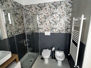 Ein modernes Badezimmer mit Duschkabine aus Glas, Toilette und Bidet.