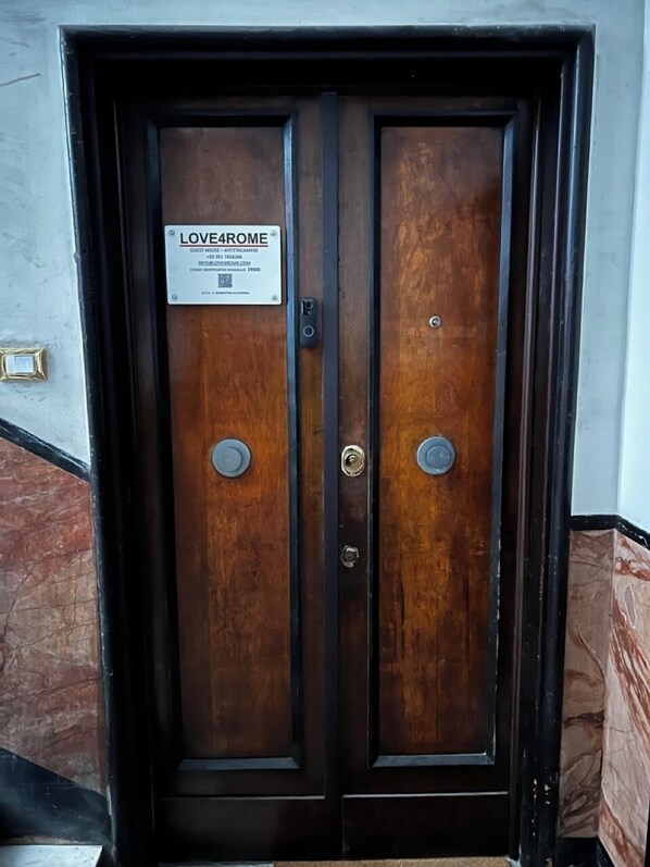 Eine Doppeltür mit einem Schild, auf dem 'LOVE4ROME' steht, und einem QR-Code.