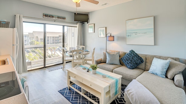 A modern living room with a sofa, coffee table, and a ceiling fan.