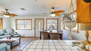 A spacious living room with a tiled floor, a dining table, two sofas, and ceiling fans. - Mtn-View Weldon Home: Walk to Pacific Crest Trail (Weldon)