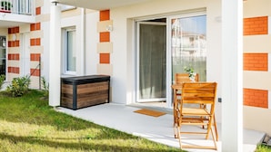 Eine moderne Wohnung mit Balkon, einer Schiebetür und einer kleinen Sitzecke im Freien.