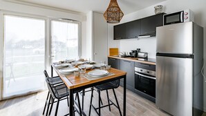 Eine moderne Küche mit Essbereich, großen Fenstern und Blick ins Freie.