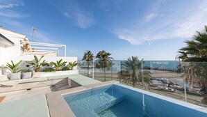 Una piscina en la azotea con vistas despejadas a la playa y al océano.