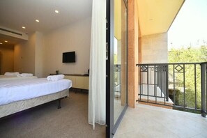 A bedroom with a bed, a television on the wall, and a balcony with a railing. - Avenue 30 Hotel (Yerevan)