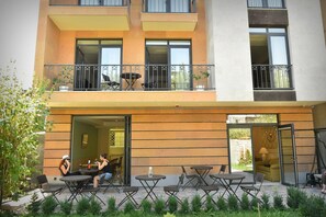 A multi-story building with outdoor seating, a balcony, and a door leading to an interior space. - Avenue 30 Hotel (Yerevan)