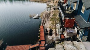 A lakeside property with a wooden deck, hot tub, and outdoor seating area. - 180 Degree view of the lake (Big Bear Lake)