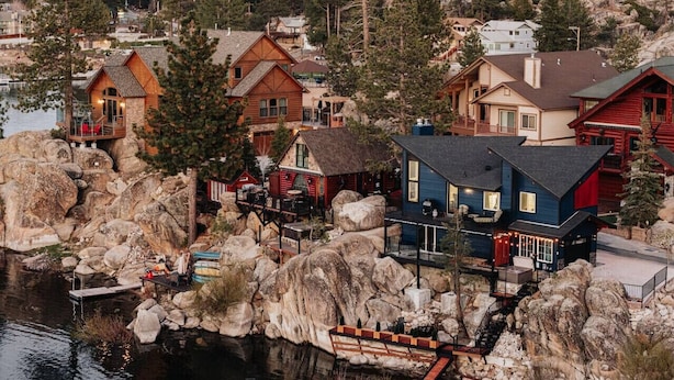 A coastal village with wooden houses, a dock, and a rocky shoreline. - 180 Degree view of the lake (Big Bear Lake)