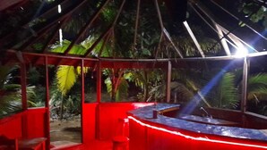 A red-roofed outdoor area with a bar, stools, and a small table. - Take it easy at our eco friendly beach cabins where life meets nature .funfilled (Westmoreland)