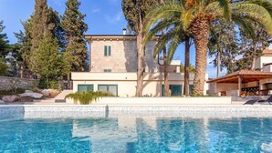 A modern villa with a swimming pool, stone walls, and green shutters. - Villa Garden Heights by MyWaycation (Hvar)