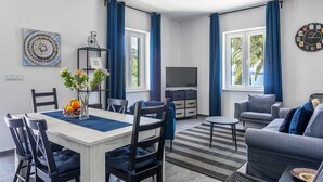 A modern living room with a dining area, large windows, and a TV. - Villa Garden Heights by MyWaycation (Hvar)