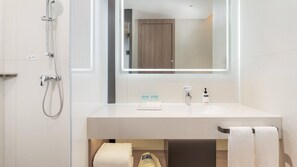 A modern bathroom with a shower, a sink, and a mirror.