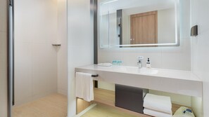 A modern bathroom with a glass shower enclosure, a white sink, and a large mirror above it. - Holiday Inn Express Yangzhou Grand Canal Theatre (Yangzhou)
