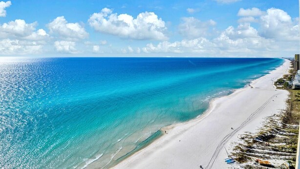 Una playa con aguas turquesas cristalinas y una orilla arenosa.