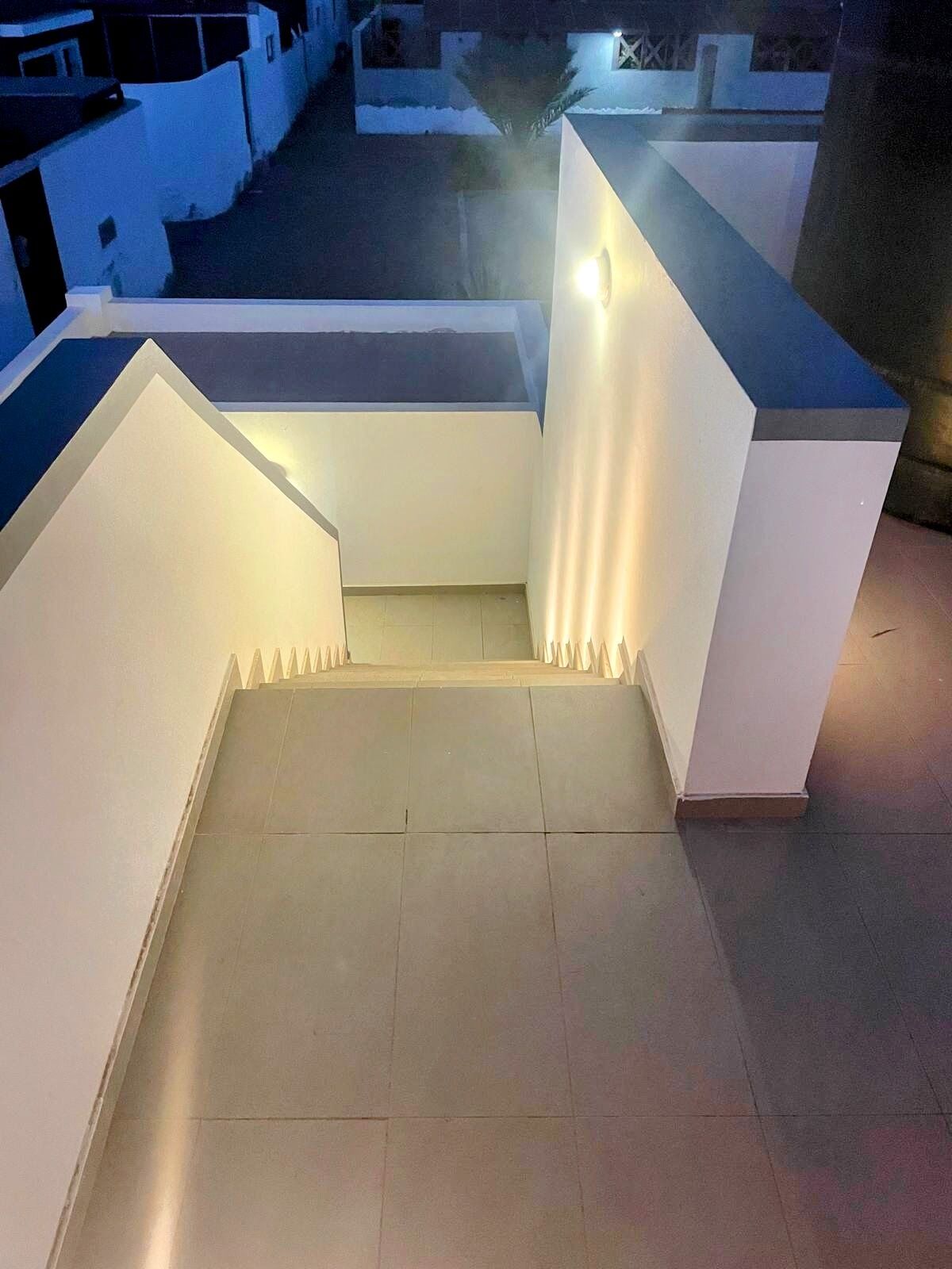 A modern outdoor staircase with a flat top and a light fixture on the right.