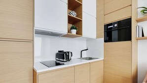 A modern kitchen with wooden cabinets, a white countertop, a built-in oven, and a coffee maker.