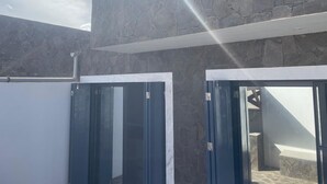 A modern building with stone-textured walls and large glass doors.