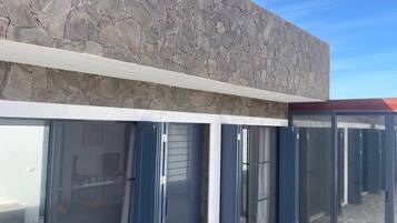 Stylish building with a rustic exterior and sliding glass doors leading to a spacious interior.
