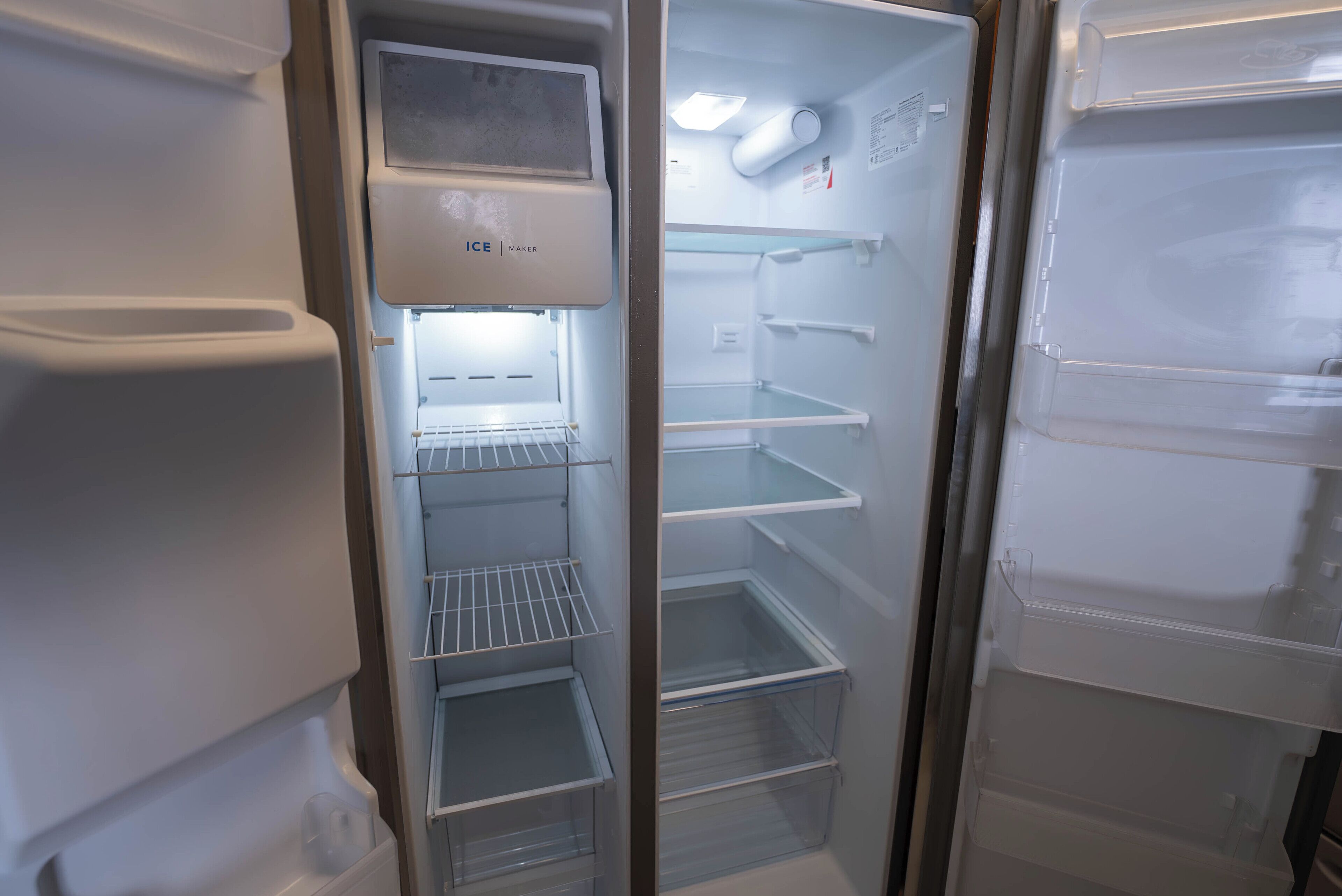 An interior view of a refrigerator with multiple shelves and a freezer compartment.