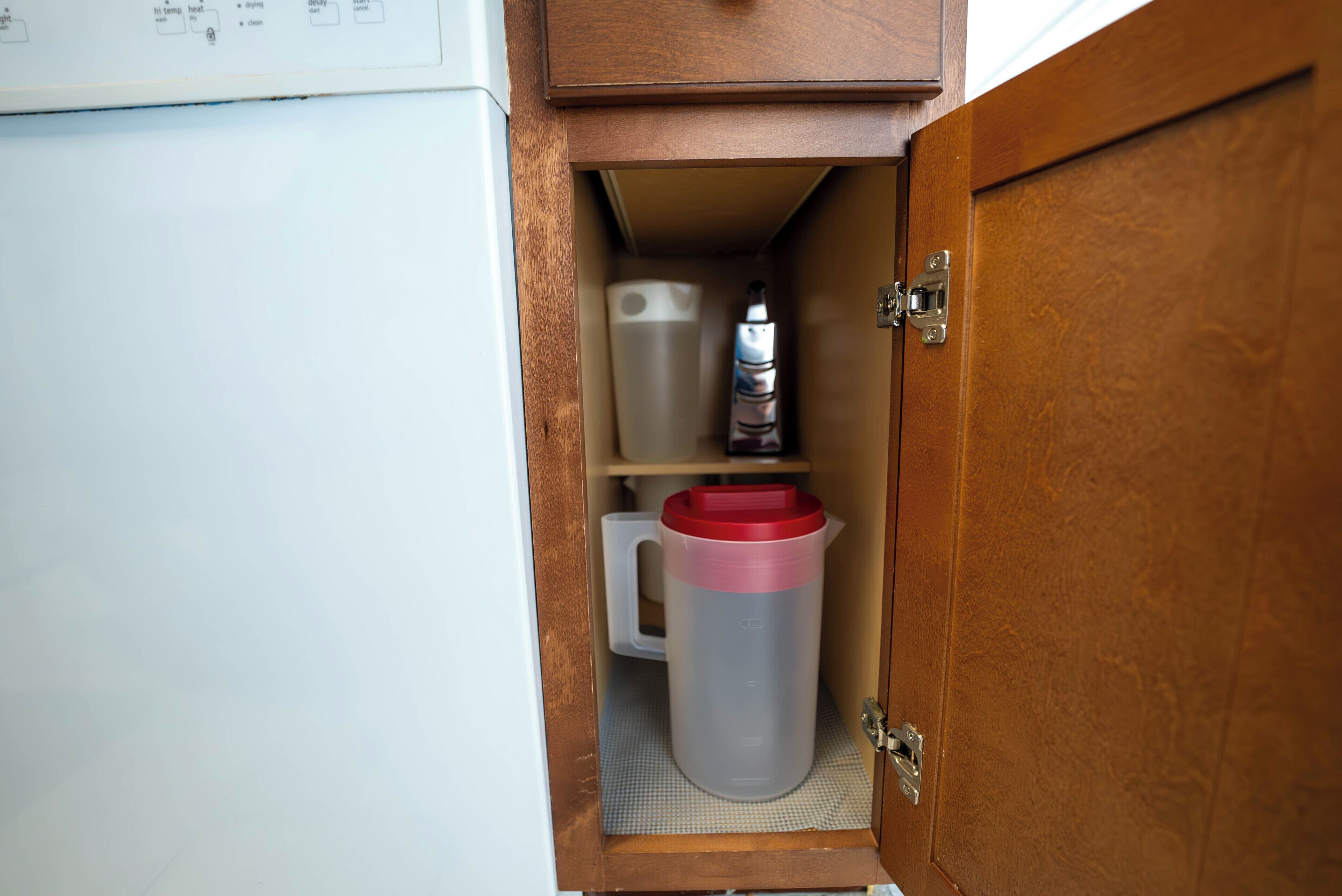 A small cabinet with a white mug and a water bottle.