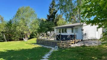 Guest house with a deck and lush surroundings.