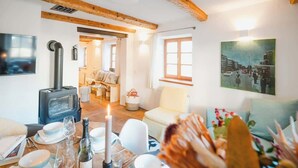 A cozy room with a fireplace, a dining table set for a meal, and a painting on the wall.