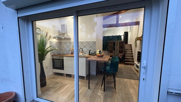 A modern kitchen with a sliding glass door leading to a dining area.