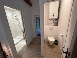 Une salle de bain moderne avec une douche à parois de verre, des toilettes et un lavabo avec un miroir.