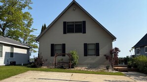 Uma casa de dois andares com varanda frontal e um pequeno jardim.