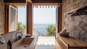 A bathroom with a large sink, a mirror, and a view of the sea. - La Valise Mazunte, Member of Small Luxury Hotels (Santa María Tonameca)