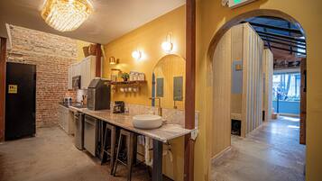 A kitchen with a brick wall, a sink, and a bar area.