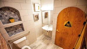 A bathroom with a toilet, sink, and a wooden door marked "Restroom". - Social Stays On State Street (Santa Barbara)
